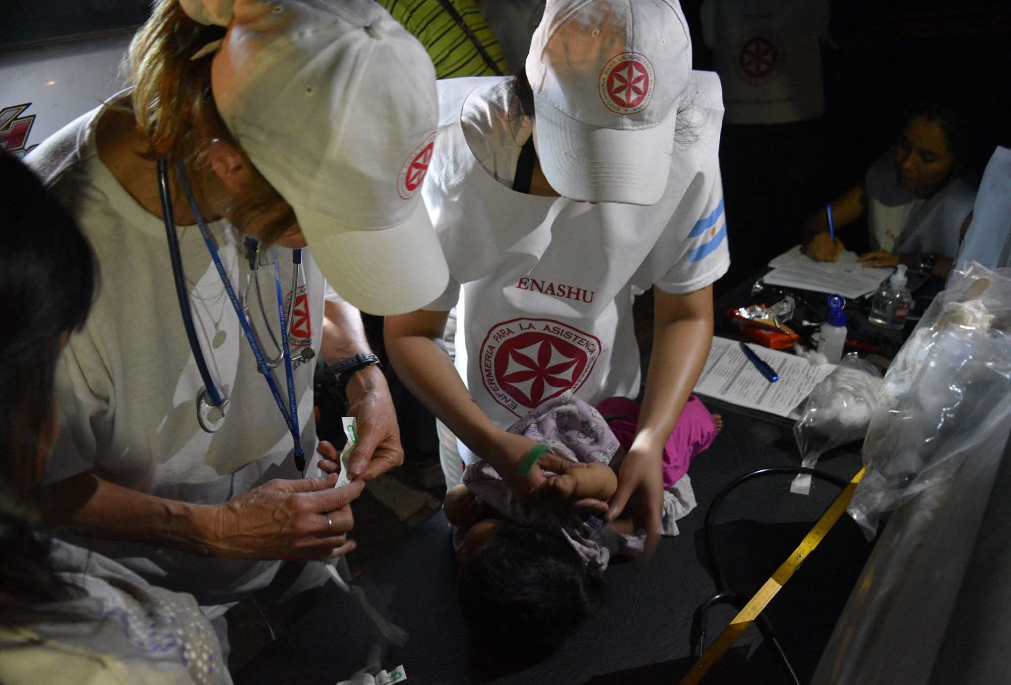 Integrantes de ENASHU atienden a un niño durante un operativo