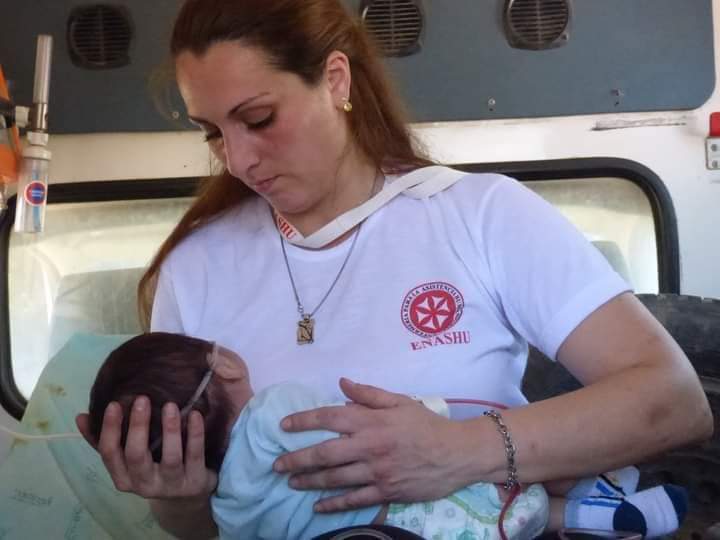 Marisa Susana Roncati atiende a un bebé durante un operativo de ENASHU